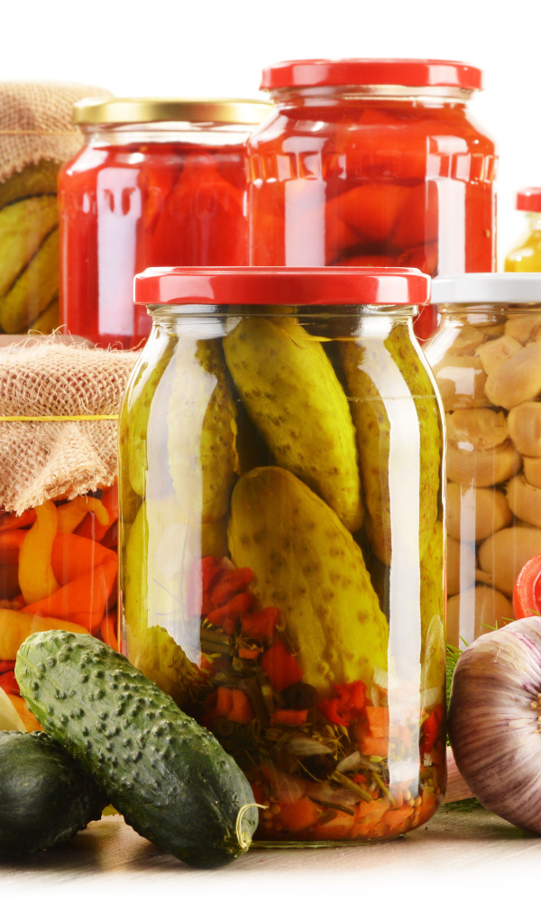 Консервация в банках на белом фоне с овощами