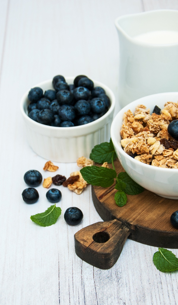 Хлопья с ягодами черники на столе с молоком