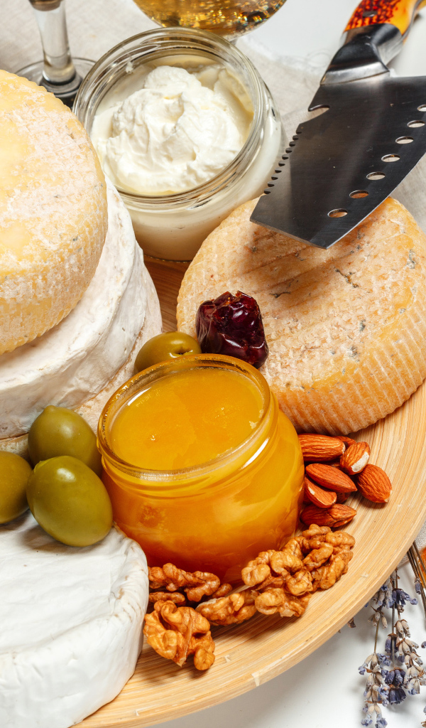 Сыр с плесенью на тарелке оливками, орехами и медом 