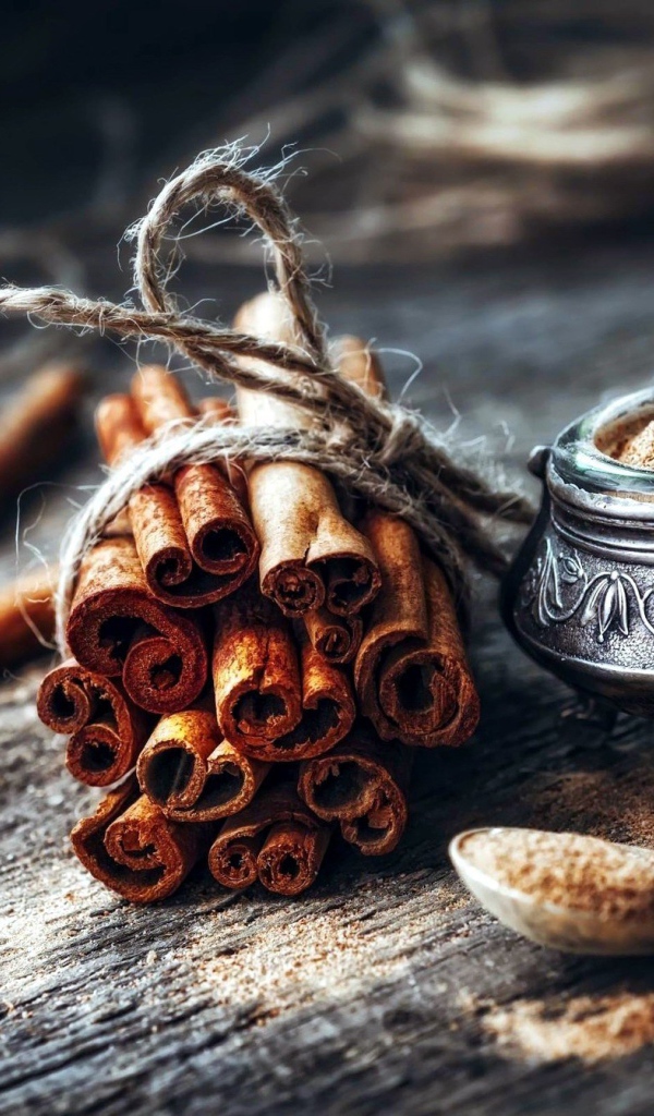 Палочки корицы на столе с молотой корицей