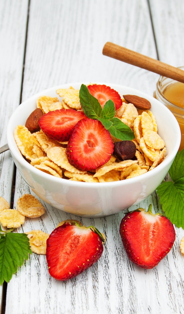 Кукурузные хлопья в миске с клубникой и медом