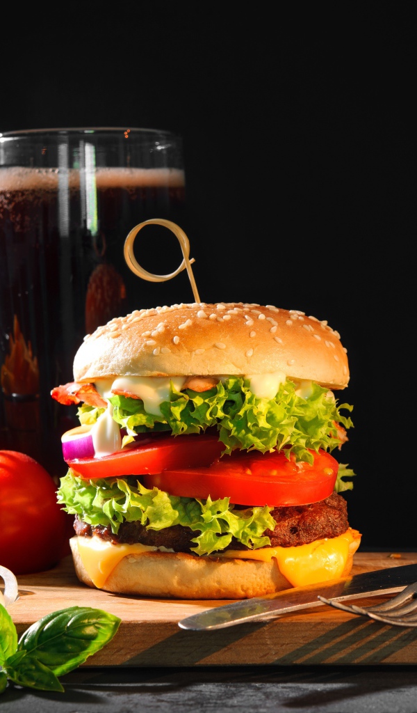 Вкусный аппетитный гамбургер на столе с пивом и картофелем фри