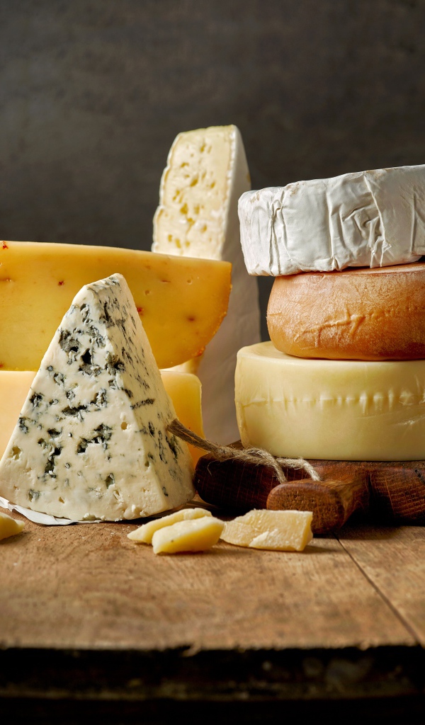 Разные виды сыра на деревянном столе 
