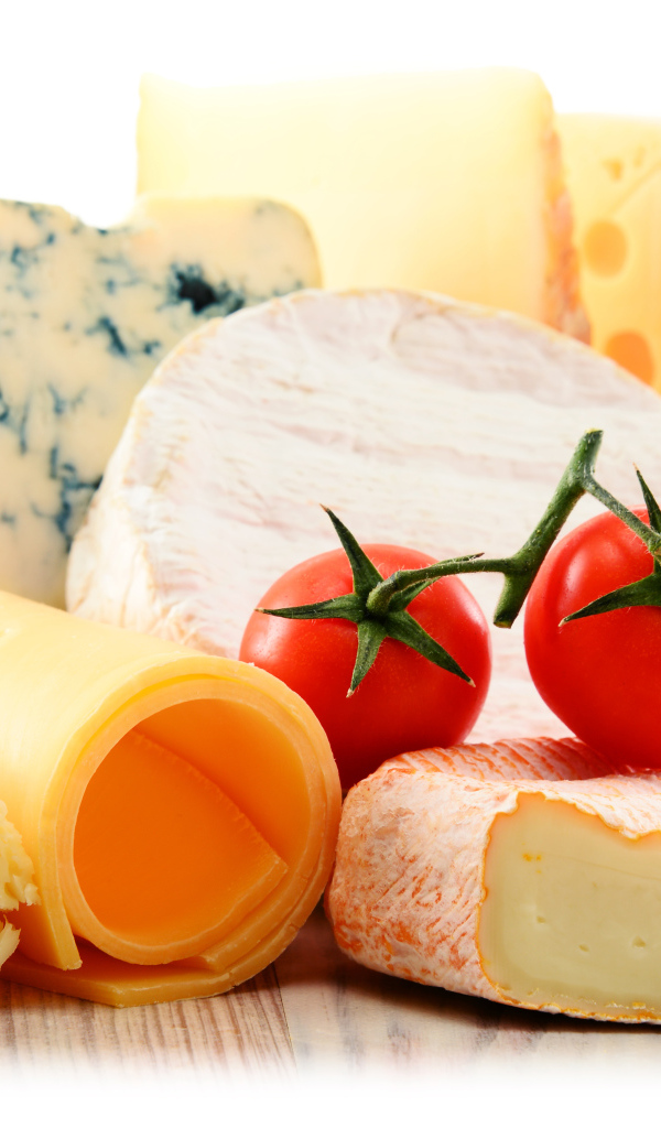 Разные виды твердого сыра на белом фоне с помидорами