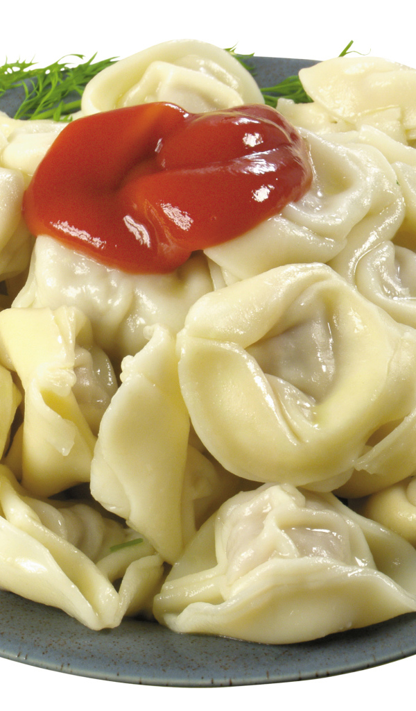 Пельмени в тарелке с кетчупом на белом фоне