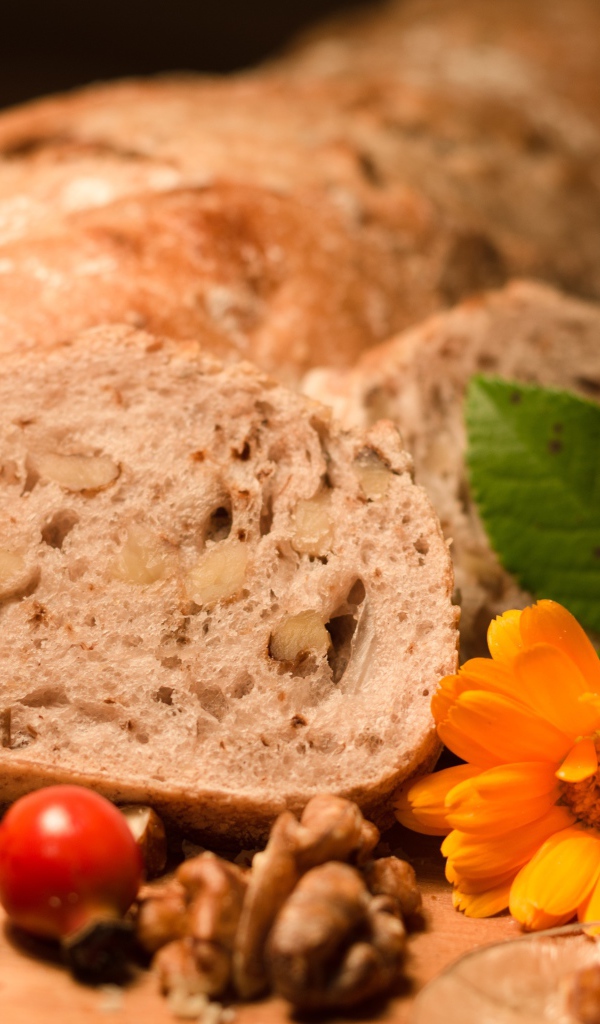 Свежий хлеб с грецкими орехами и цветами календулы на столе