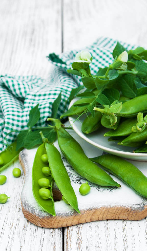 Свежий зеленый горох на столе с полотенцем