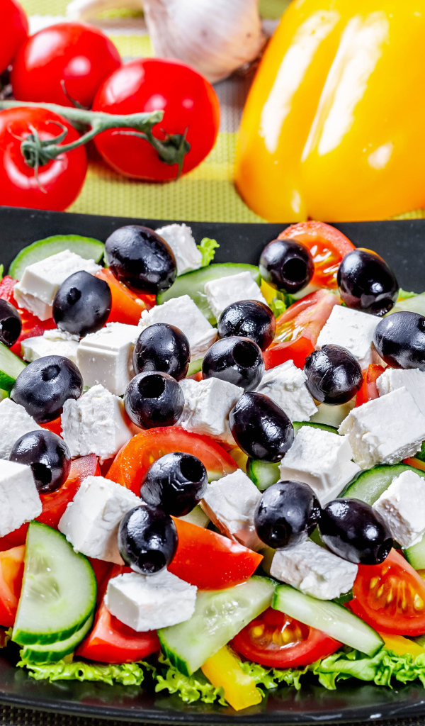 Греческий салат на столе со свежими овощами 