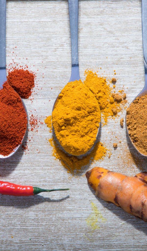 Молотые специи в ложках на столе 