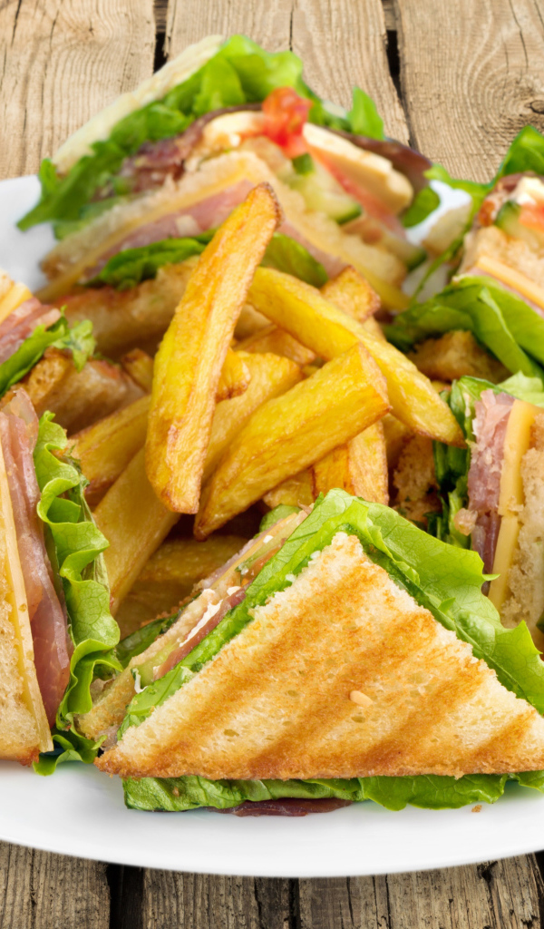 Сэндвичи с ветчиной на тарелке с картофелем фри 