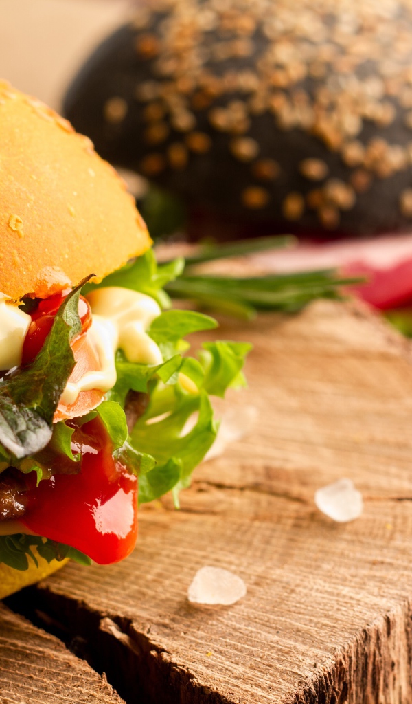 Гамбургер на деревянной доске крупным планом