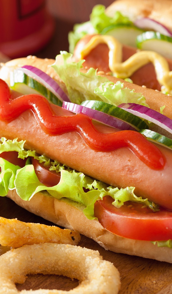 Хотдоги с овощами на разделочной доске с картофелем фри