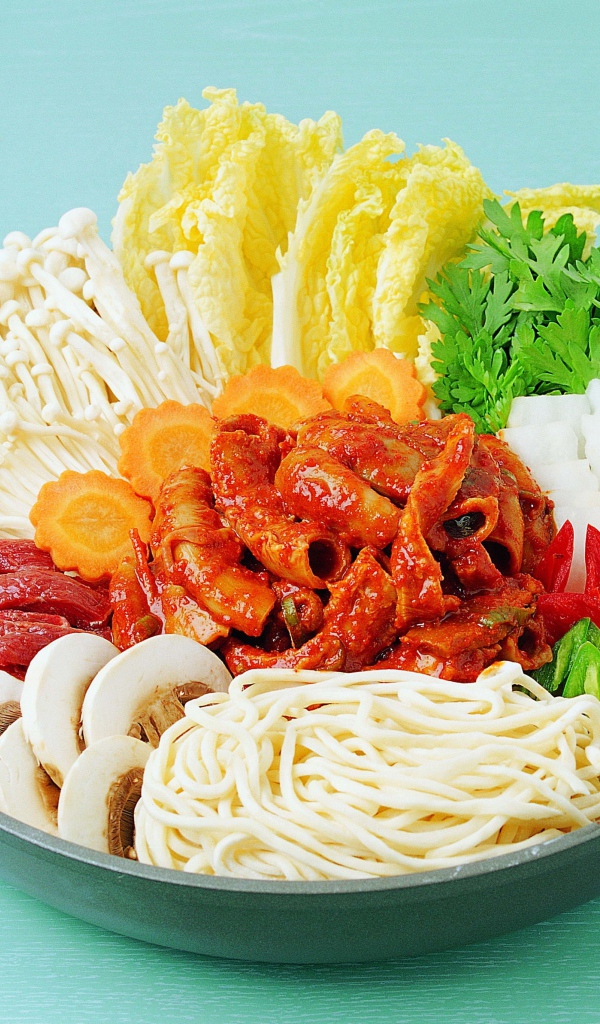 Мясо в тарелке с овощами, грибами и лапшой на голубом фоне