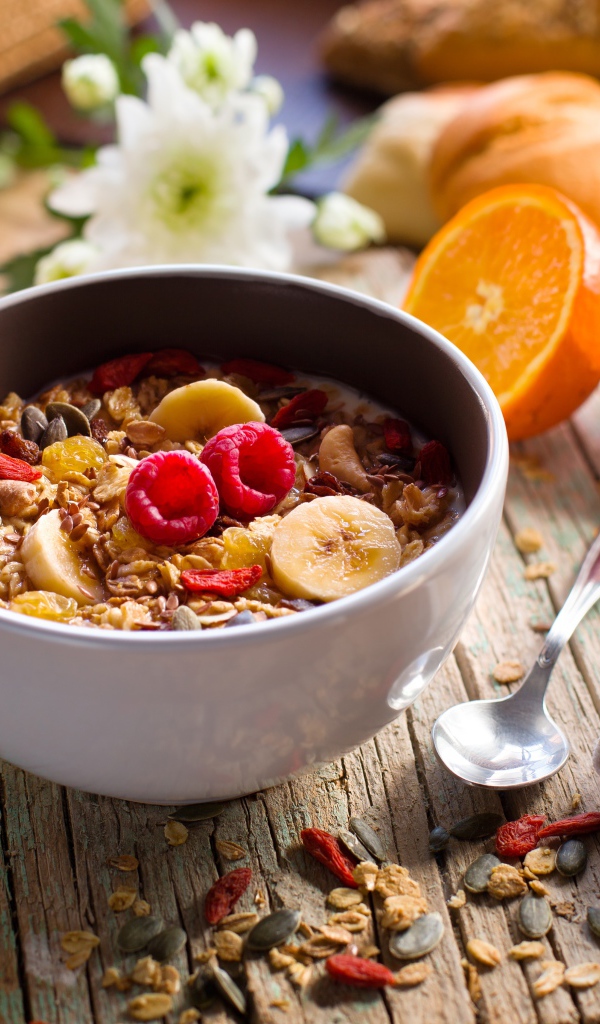 Мюсли в миске с молоком на завтрак с соком и апельсинами 