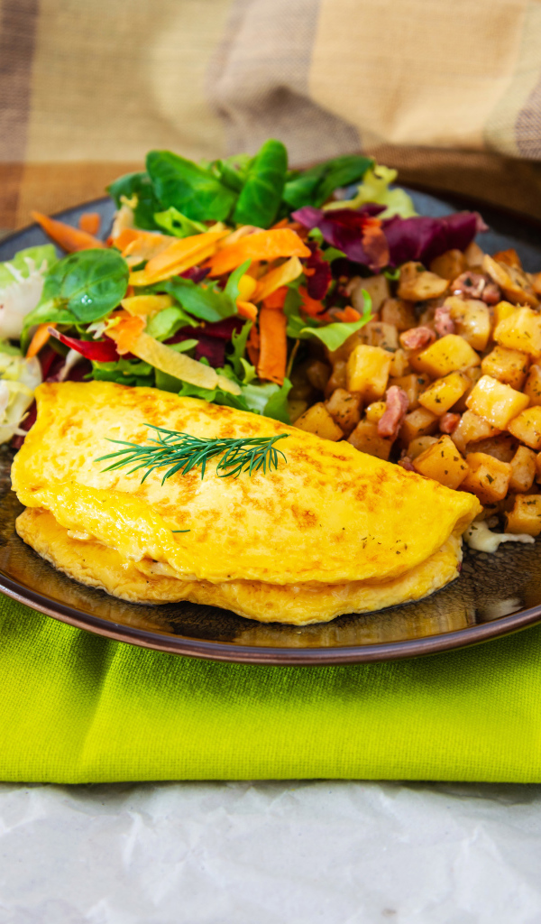 Омлет на тарелке с салатом и овощами