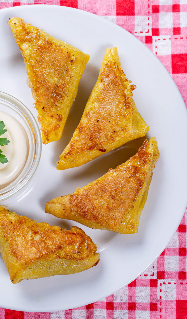 Блинчики со сметаной на столе со столовыми приборами 