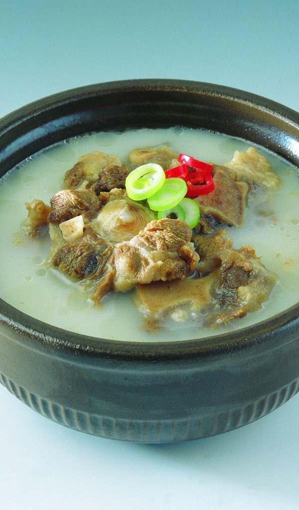 Тарелка супа с говядиной  на голубом фоне