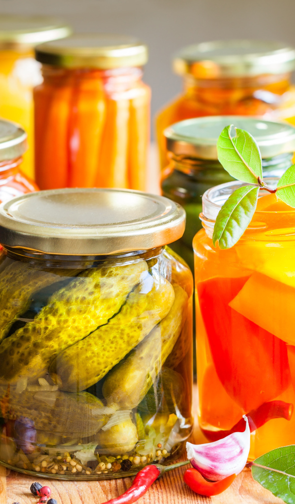 Консервация в стеклянных банках на столе со специями