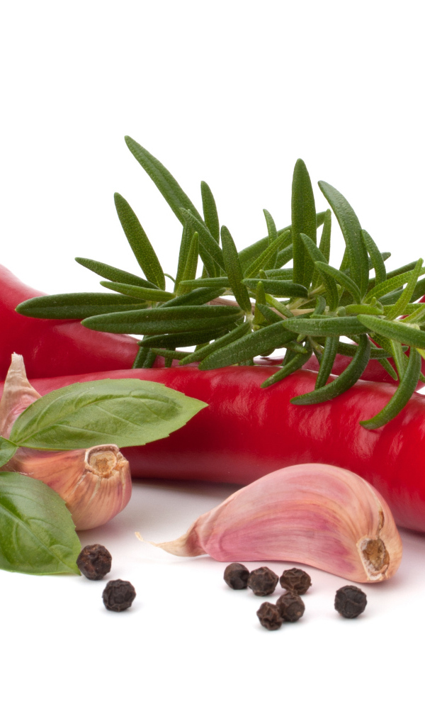 Красный перец с чесноком, базиликом, черным перцем и розмарином на белом фоне