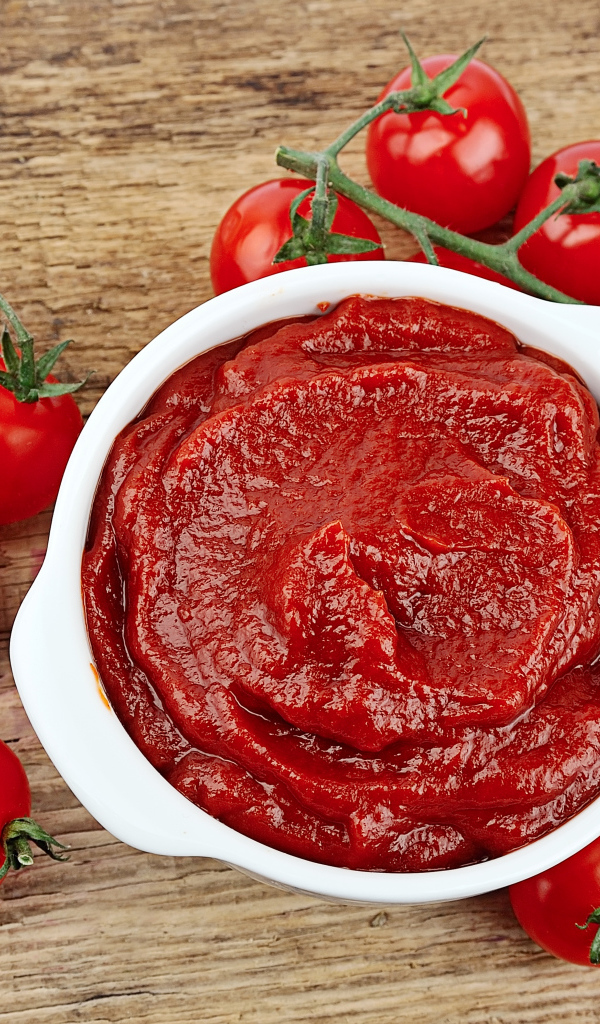 Красные спелые помидоры на столе с кетчупом