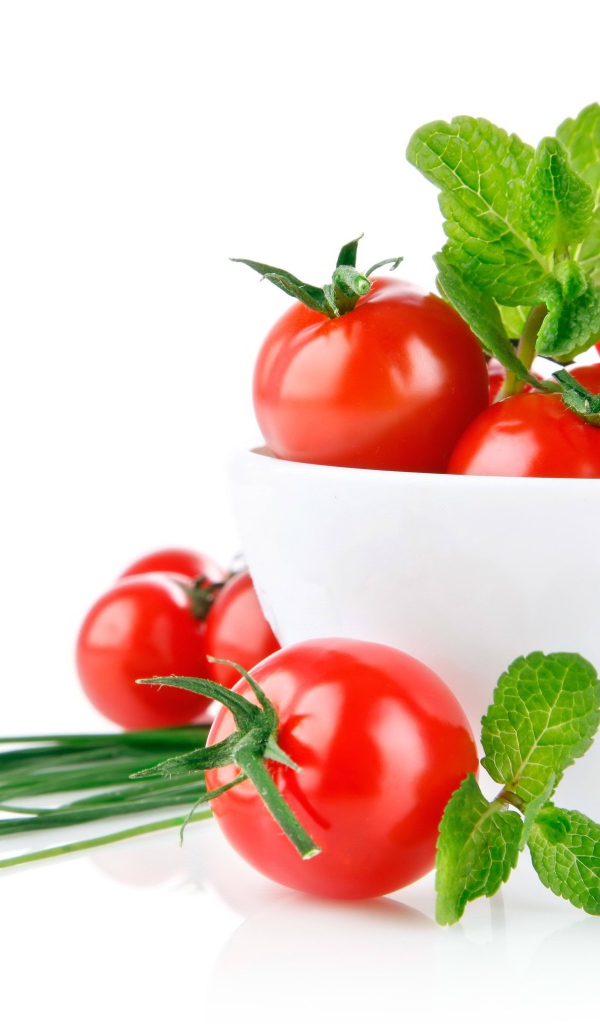 Красные помидоры с зеленым луком на белом фоне