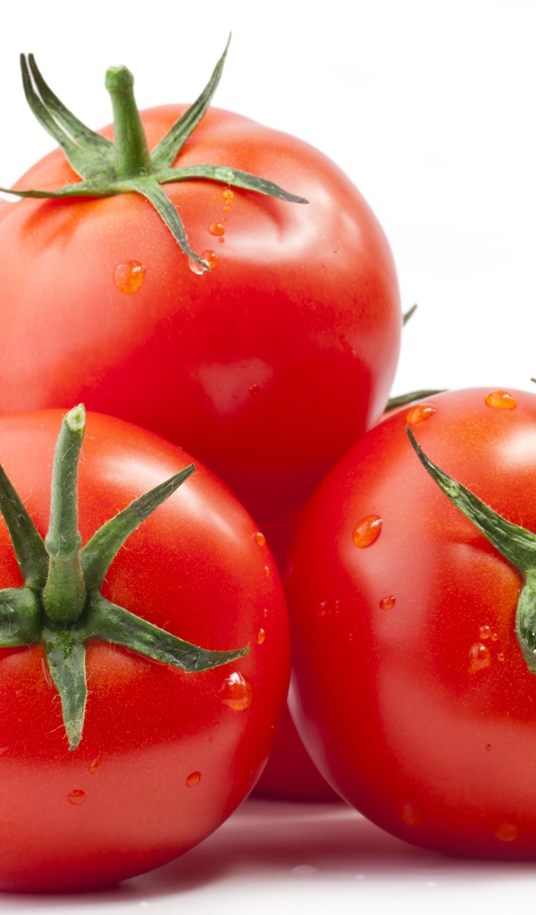 Спелые большие томаты на белом фоне