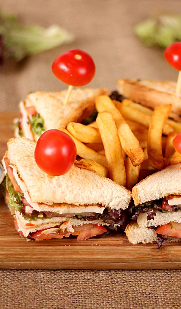 Сэндвичи на доске с картофелем фри и соусом