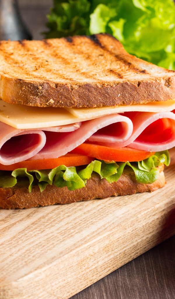 Бутерброды на столе с помидорами и листьями салата