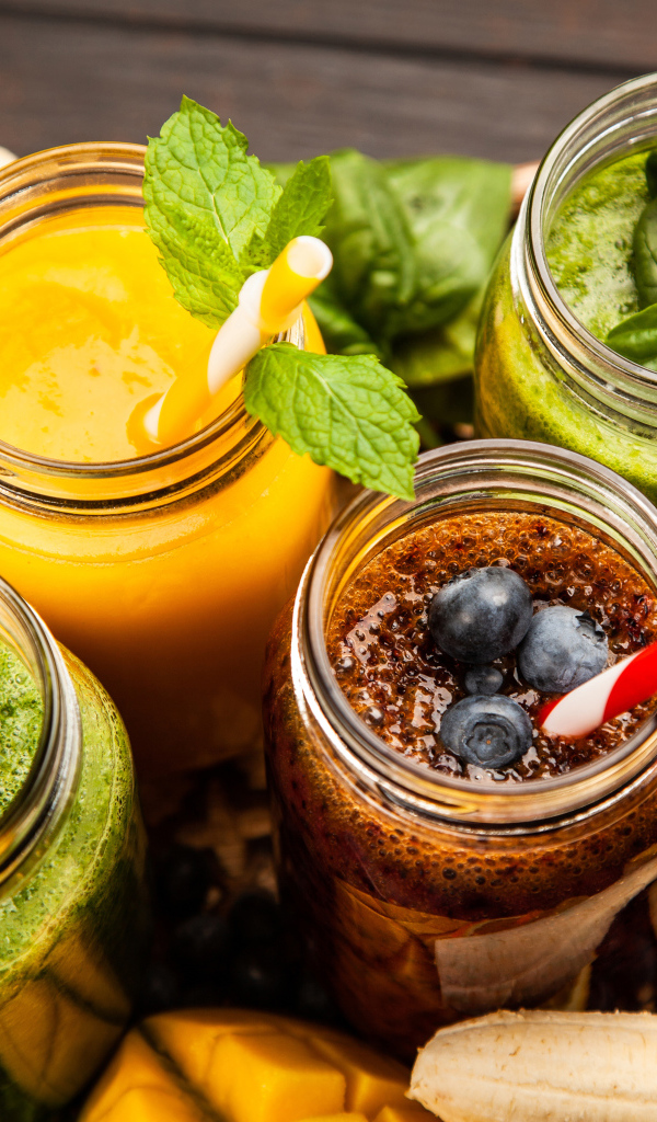 Банки со смузи на столе с бананами