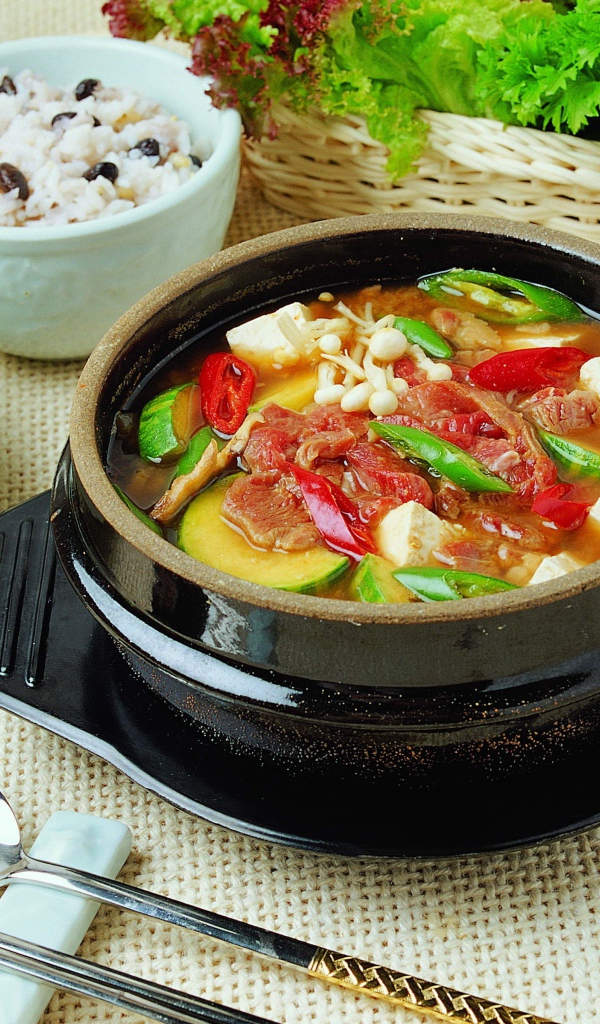 Суп с овощами и мясом на столе с закусками 