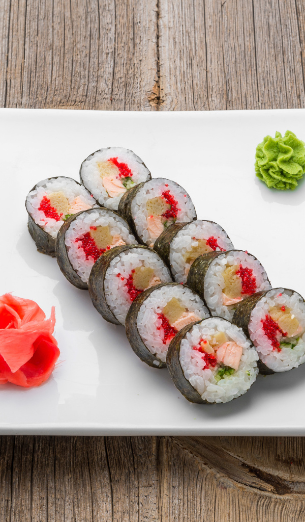 Суши на большой белой тарелке с соусом васаби и имбирем на столе соевым соусом