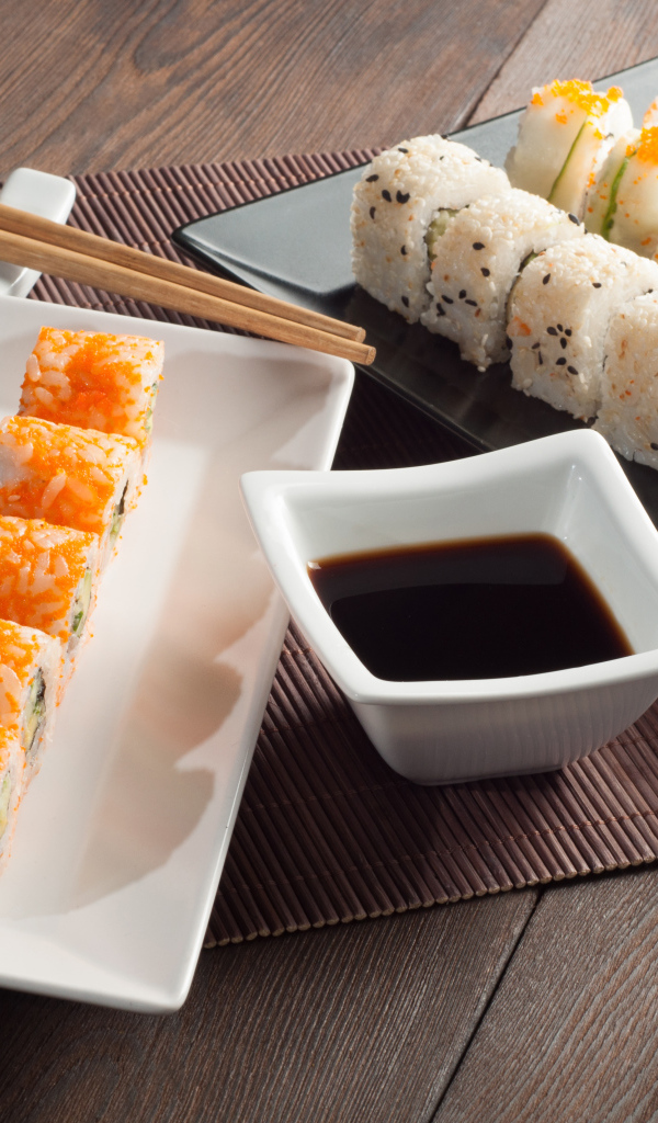 Суши на столе с соевым соусом и палочками