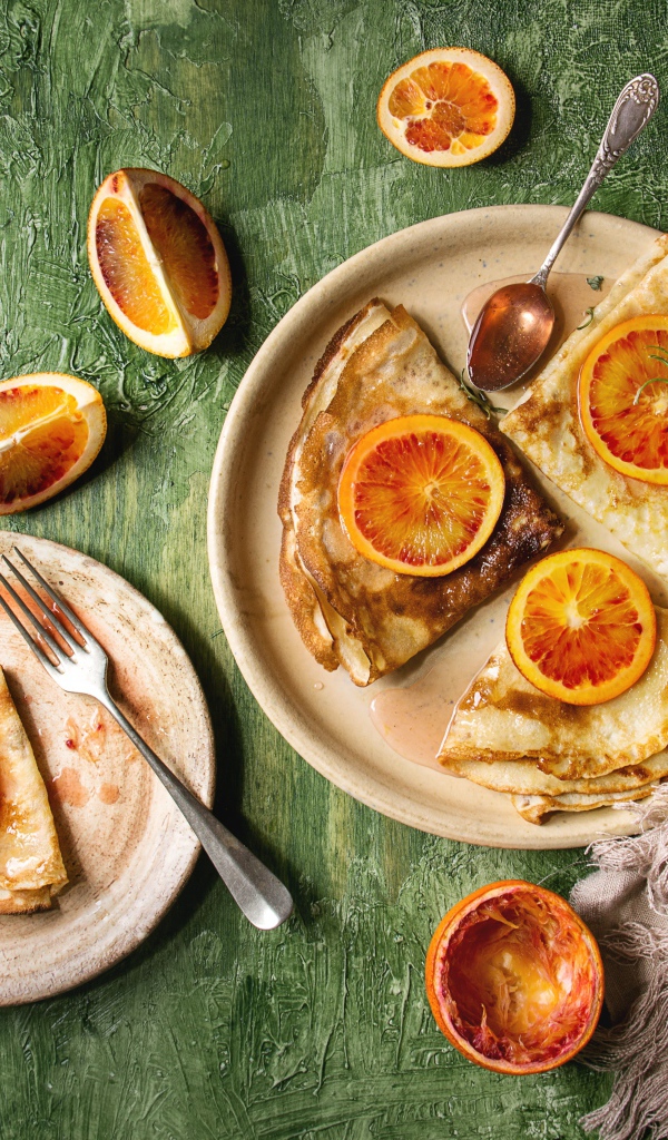 Тонкие блинчики с апельсинами на столе