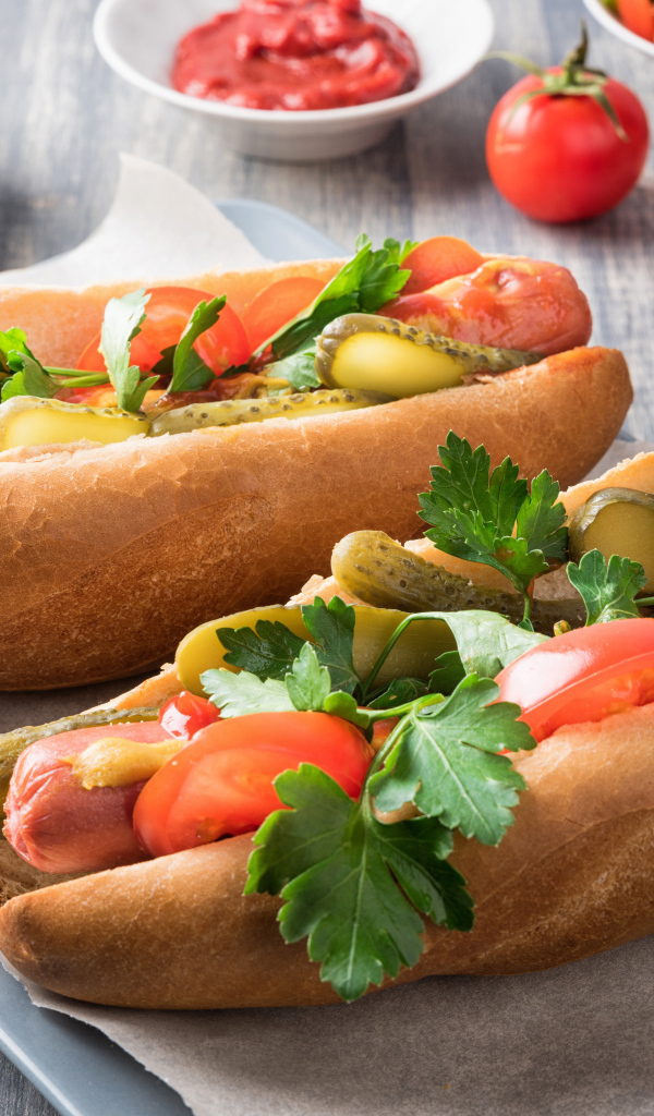 Два хотдога с сосиской, огурцами и помидорами