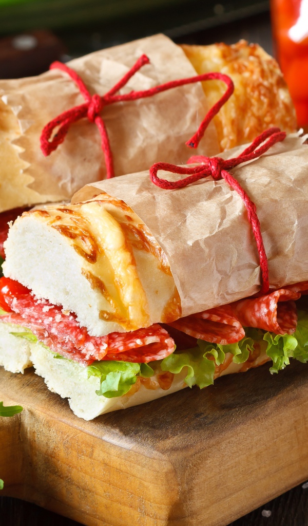 Два огромных бутерброда с колбасой и листьями салата