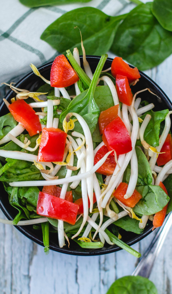 Овощной салат в миске на столе с вилкой