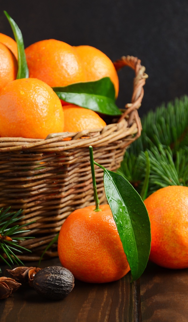 Корзина с мандаринами на столе со специями