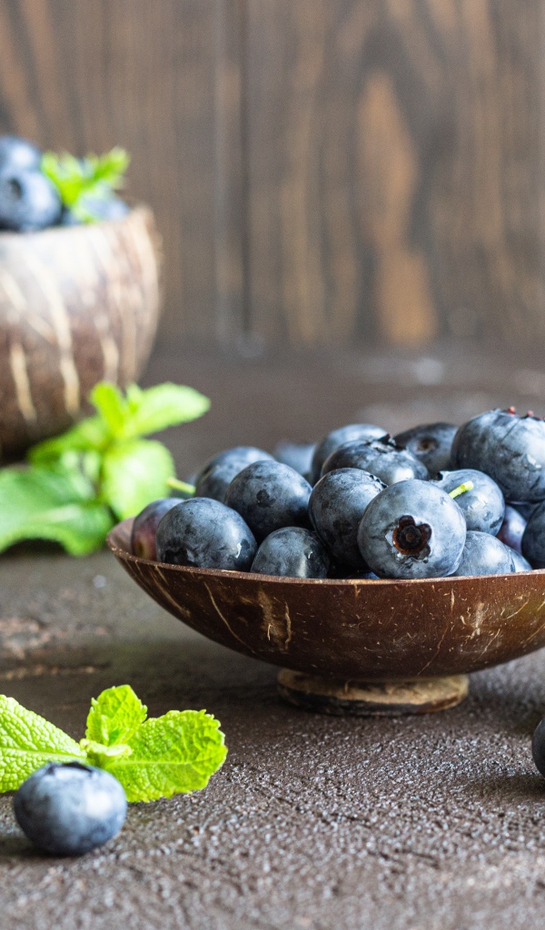 Ягоды черники стоят на столе в посуде