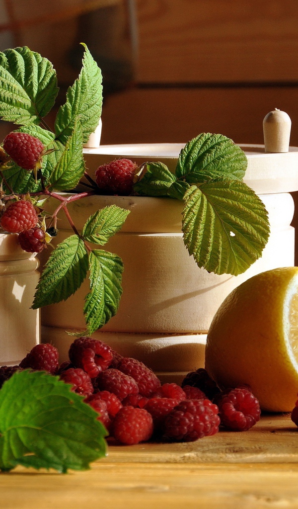 Посуда на столе с малиной и лимоном