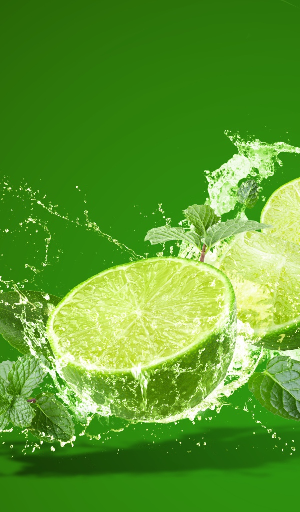 Лайм с мятой в брызгах воды на зеленом фоне