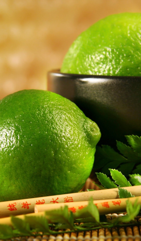 Лаймы на столе с палочками и листьями