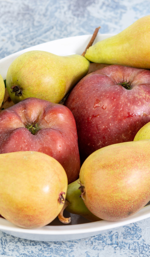 Красные яблок и груши на тарелке на столе