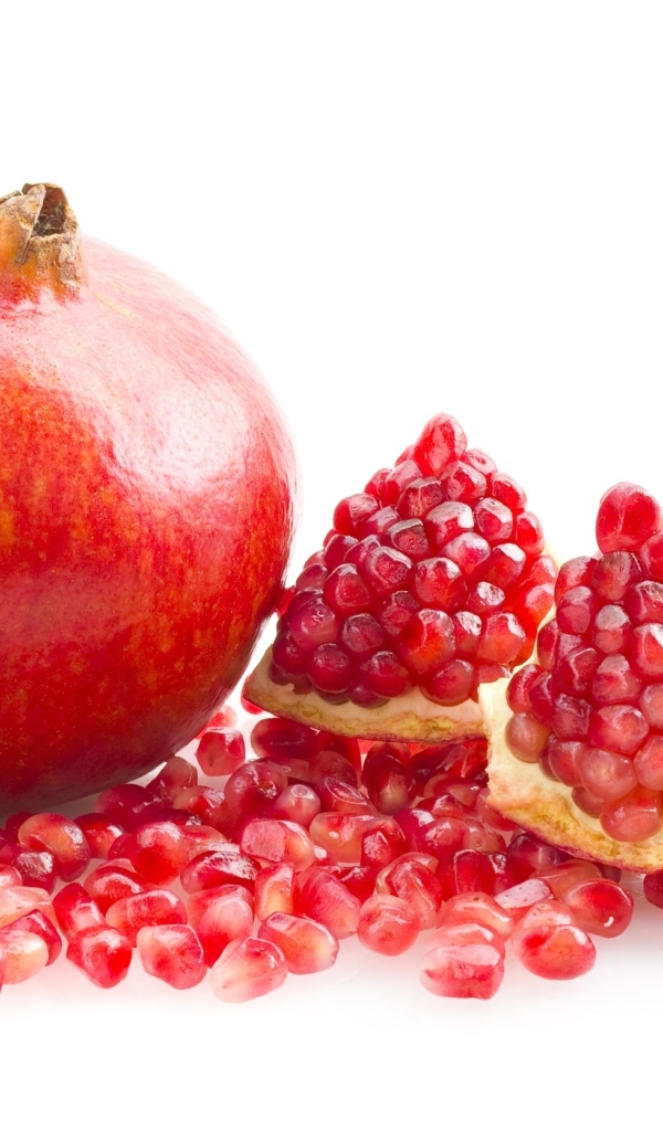 Красный гранат с зернами на белом фоне