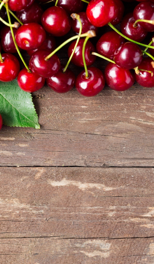 Красные спелые вишни на деревянном столе