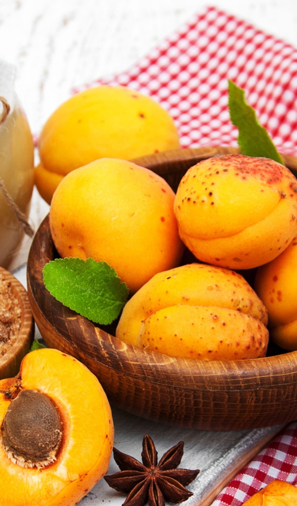 Спелые абрикосы на столе с бадьяном, коричневым сахаром и джемом