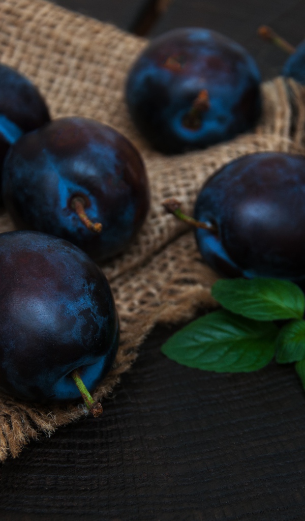 Спелые синие сливы на столе