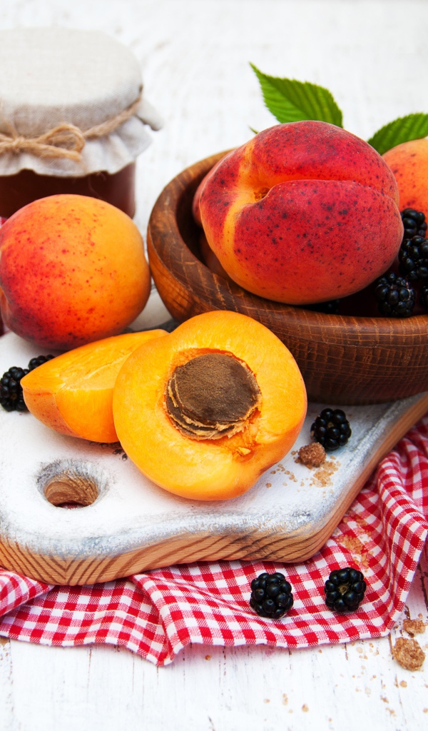 Спелые сочные абрикосы на столе с ягодами черники