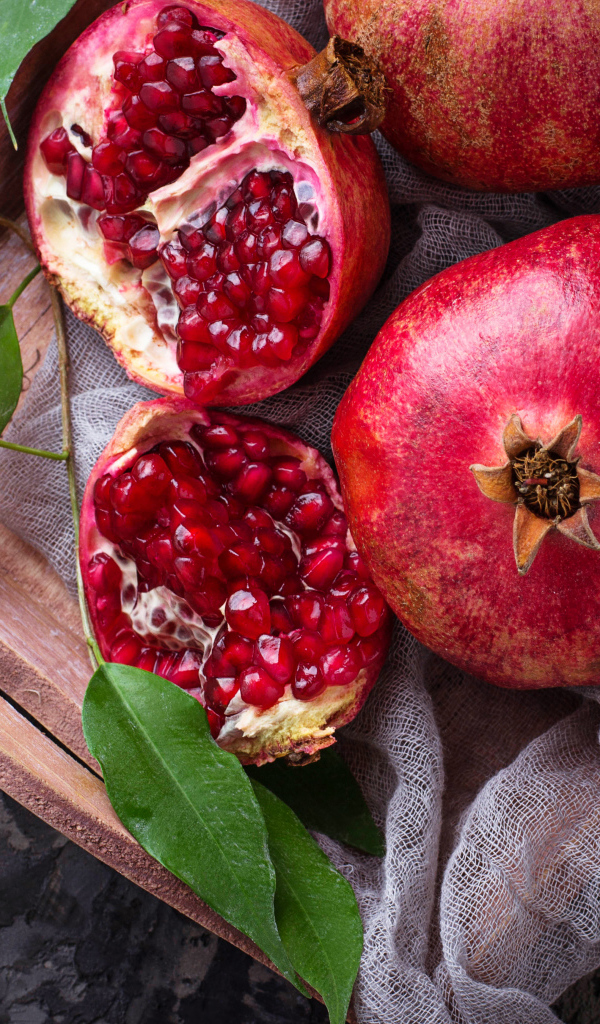 Спелые красные гранаты в деревянном ящике