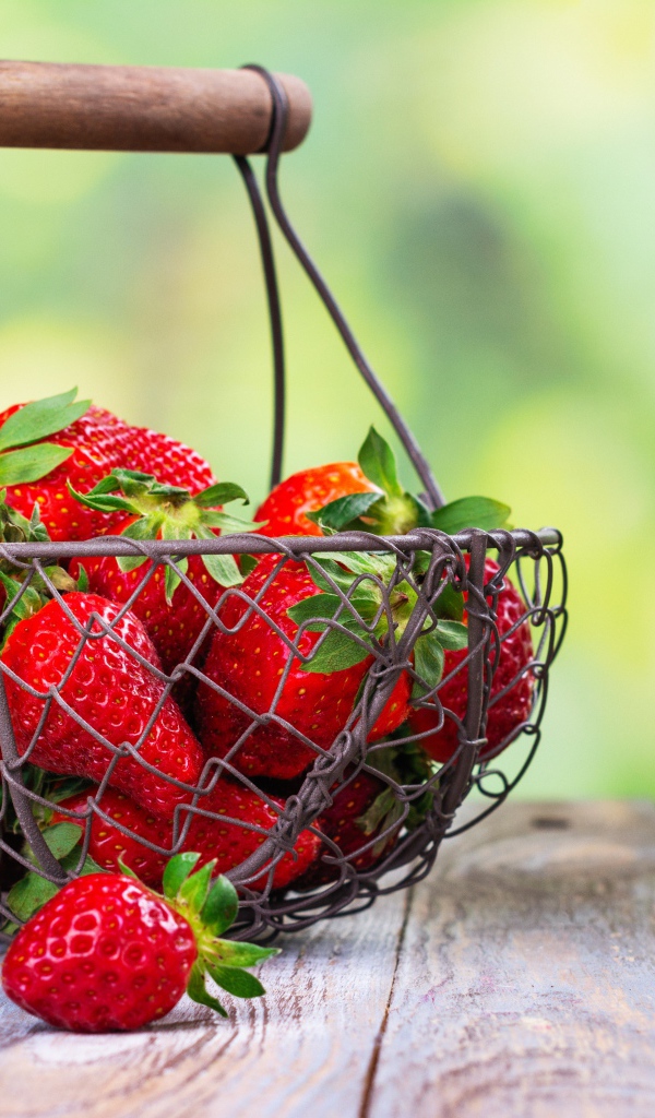 Спелая красная клубника в корзине на столе