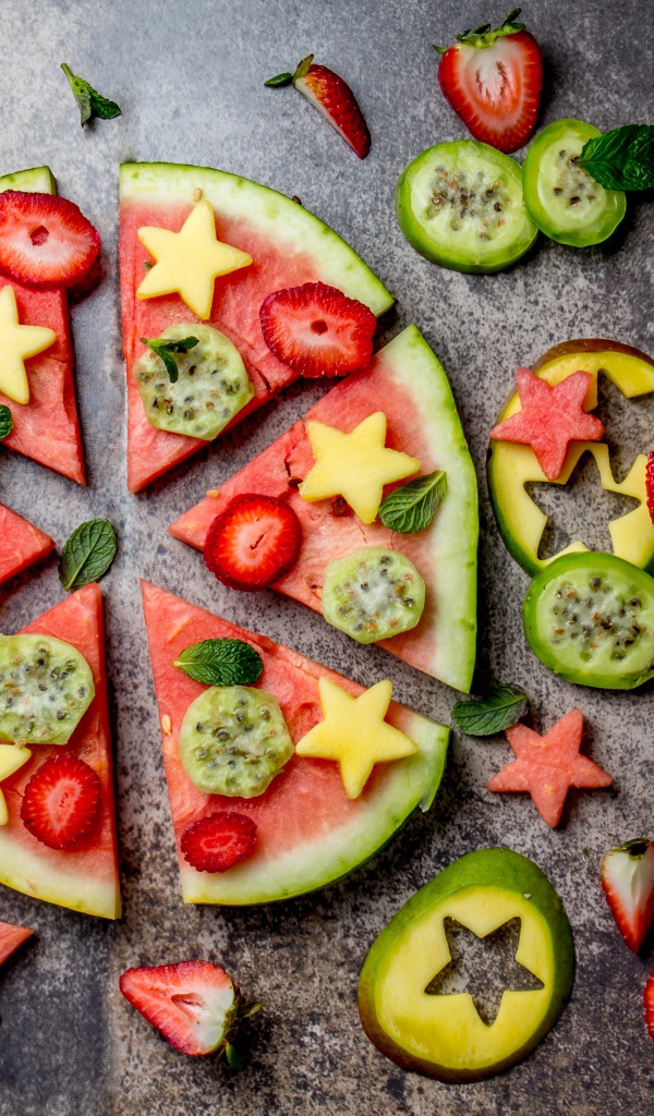 Кусочки арбуза с фруктами на сером фоне